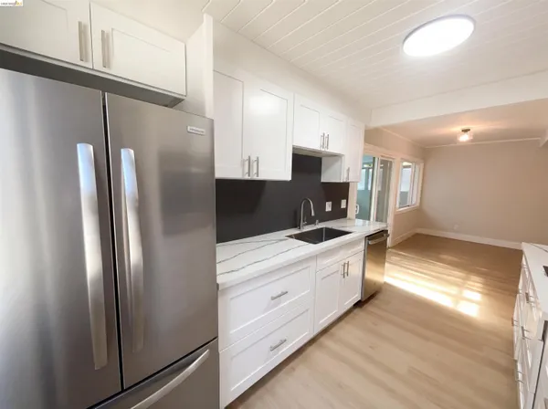 a kitchen with stainless steel appliances a refrigerator sink and cabinets