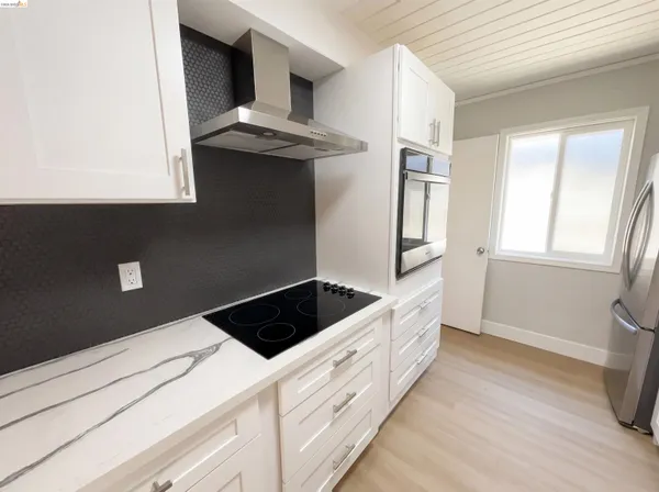 a kitchen with stainless steel appliances granite countertop a refrigerator and a stove