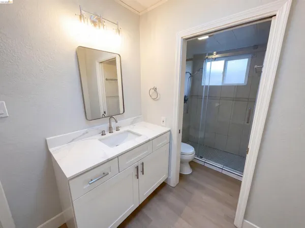 a bathroom with a toilet a sink a mirror and a shower
