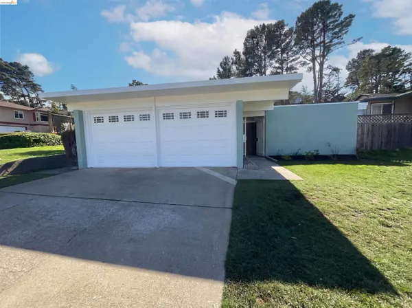 a view of a house with a yard and a garage