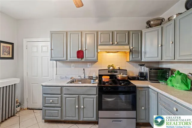 a kitchen with granite countertop a sink stainless steel appliances and cabinets