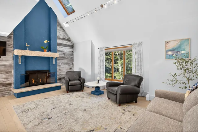 a living room with stainless steel appliances furniture stove and a window