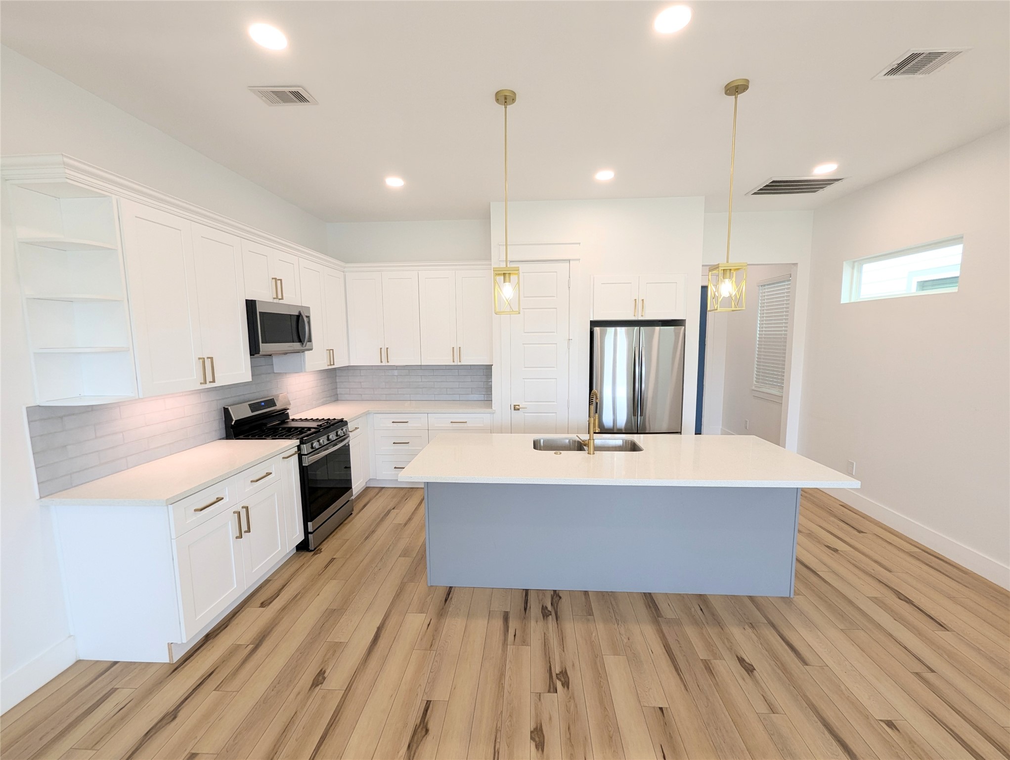 4913 Fisk Street Houston, TX 77009 - Photo 3 of 27 a large kitchen with kitchen island a white counter space stainless steel appliances and cabinets