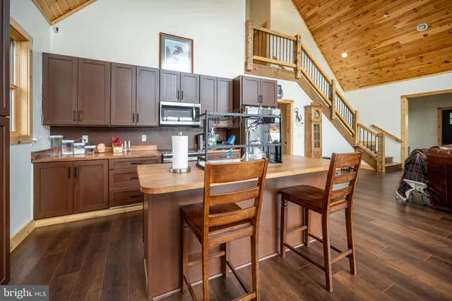 a kitchen with a sink a stove cabinets and wooden floor