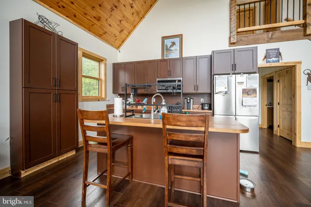a kitchen with stainless steel appliances granite countertop a refrigerator and a stove top oven