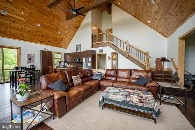 a living room with furniture a wooden floor and next to a window