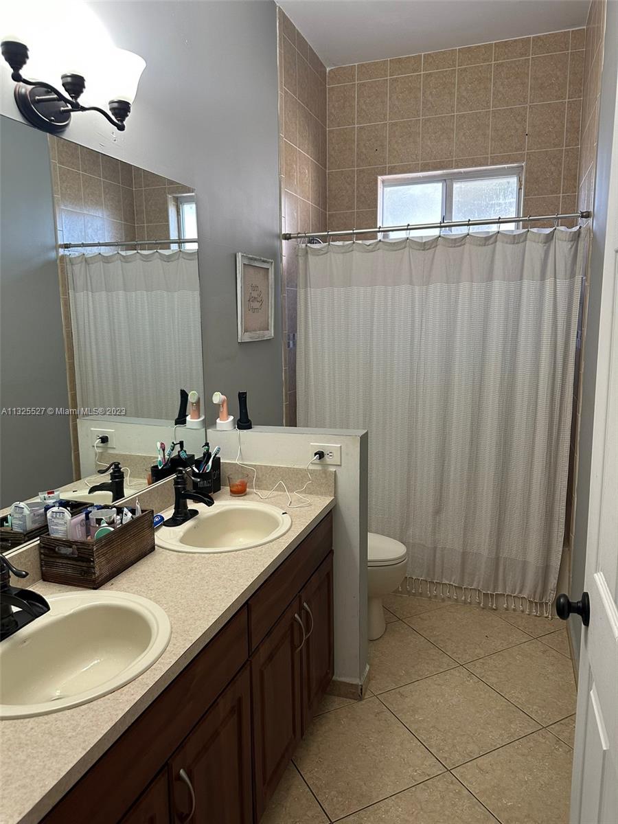 20565 Southwest 326th Street Homestead, FL 33030 - Photo 15 of 28 a bathroom with a double vanity sink and a mirror
