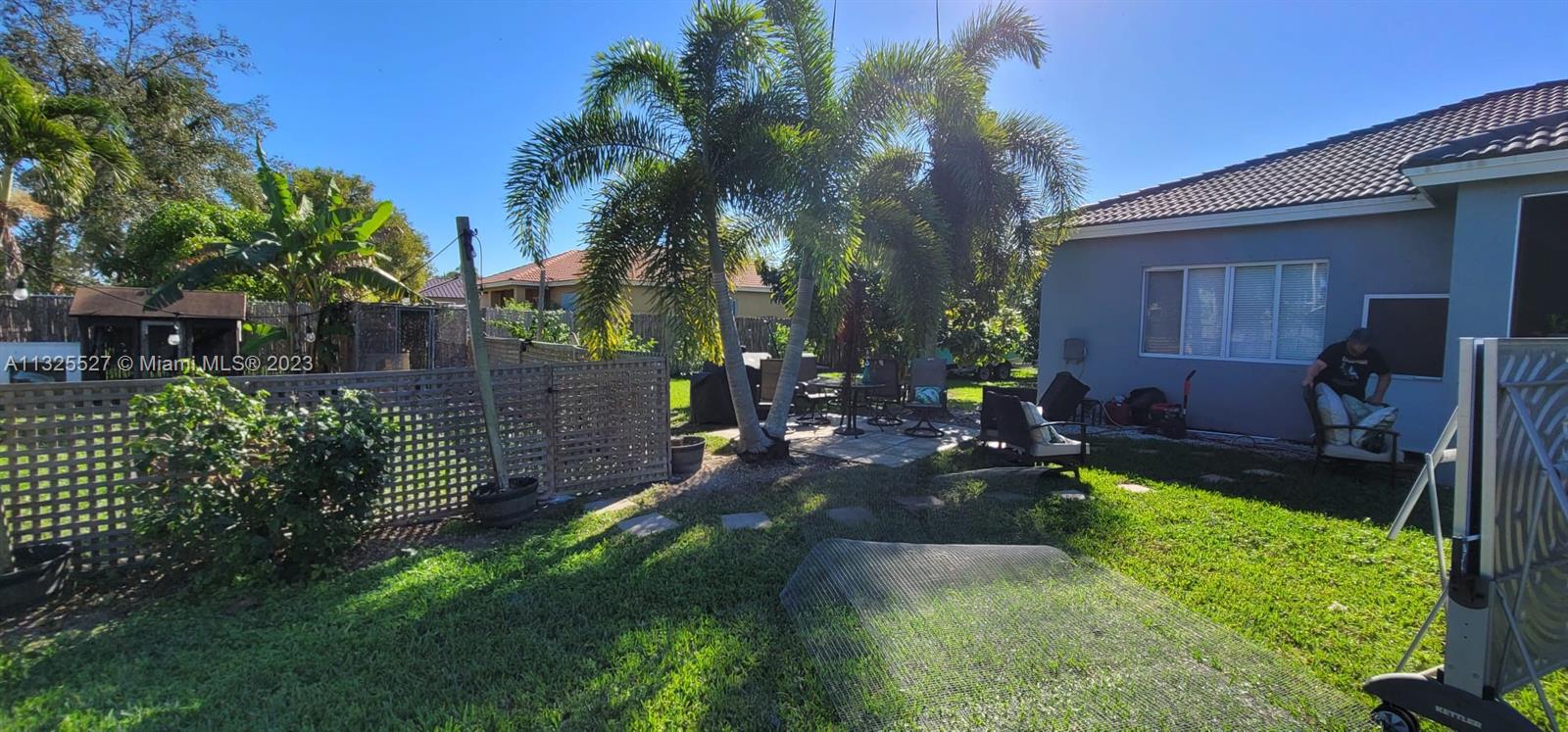 20565 Southwest 326th Street Homestead, FL 33030 - Photo 22 of 28 a view of a backyard with table and chairs with wooden fence