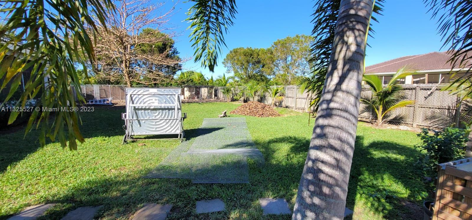 20565 Southwest 326th Street Homestead, FL 33030 - Photo 23 of 28 a green field with trees in front of it
