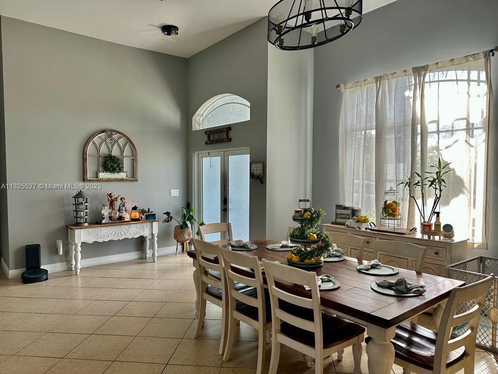 20565 Southwest 326th Street Homestead, FL 33030 - Photo 3 of 28 a view of a dining room with furniture and a large window