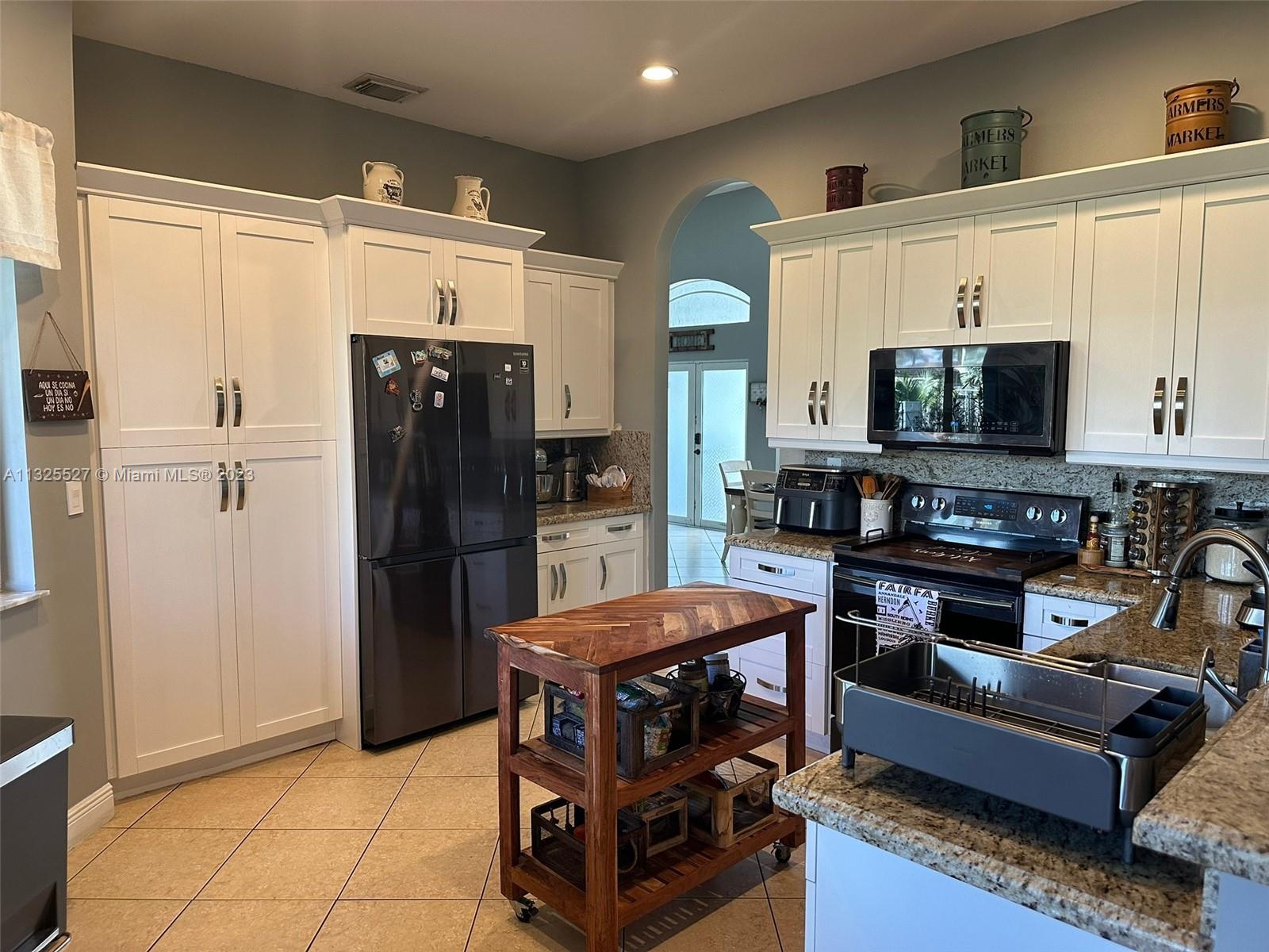 20565 Southwest 326th Street Homestead, FL 33030 - Photo 8 of 28 a kitchen with stainless steel appliances a refrigerator a stove and a sink