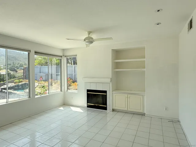 a view of an empty room with a fireplace and a window