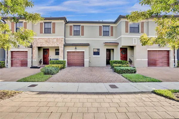 a front view of a house with a yard and a garage