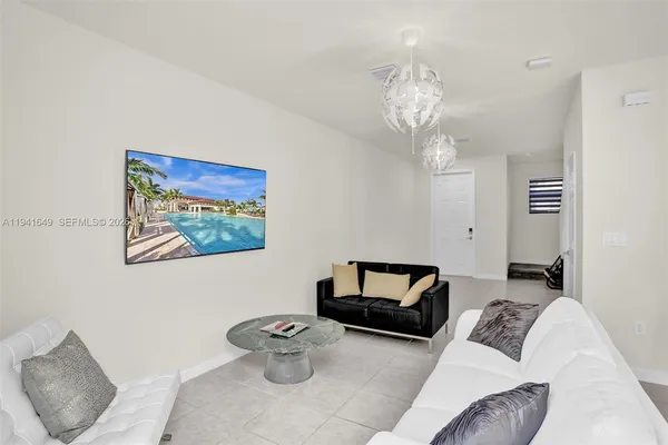 a living room with furniture and a chandelier