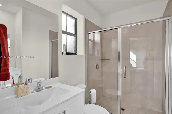 a bathroom with a sink shower and a mirror