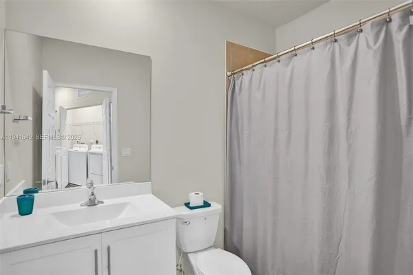 a bathroom with a sink a toilet and shower curtain