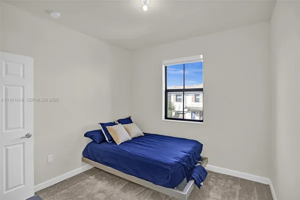 a bed sitting in a bedroom next to a window