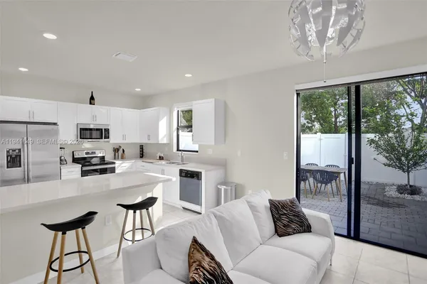 a living room with furniture a large window and a chandelier