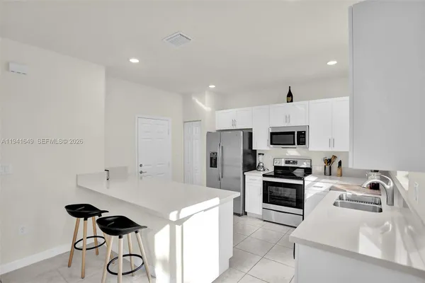 a kitchen with stainless steel appliances a stove a sink and a refrigerator