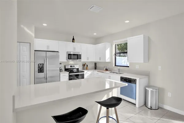 a kitchen with white cabinets and stainless steel appliances