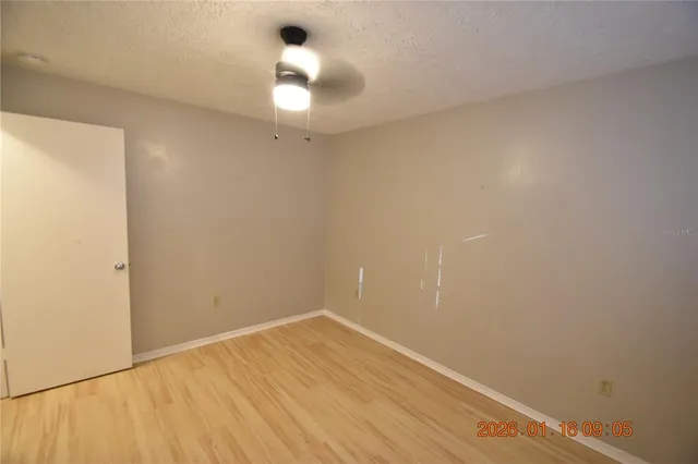 a view of a room with wooden floor and fan