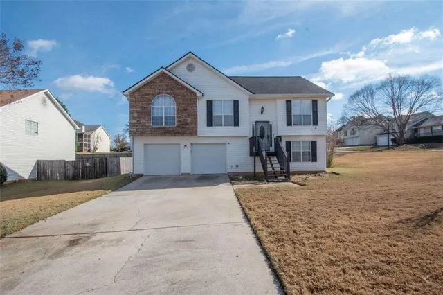 a view of a house with a yard and garage