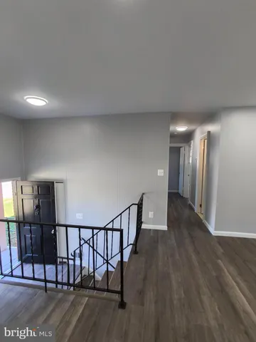 an empty room with wooden floor and entrance