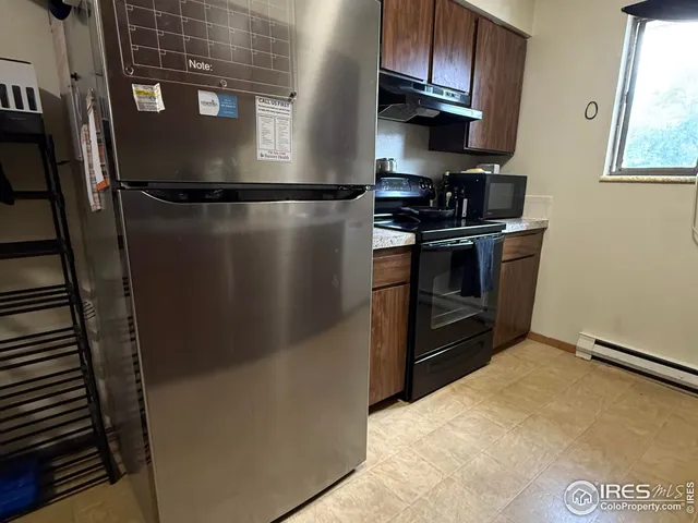 a kitchen with stainless steel appliances granite countertop a refrigerator a stove and a sink