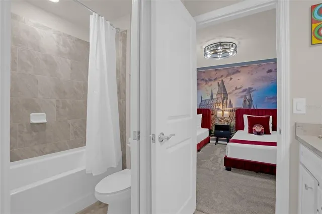 a bedroom with a large bed and a chandelier