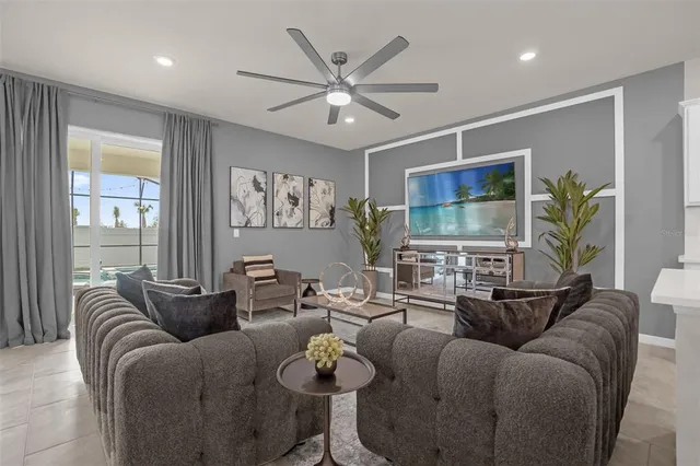 a living room with furniture a chandelier and a flat screen tv