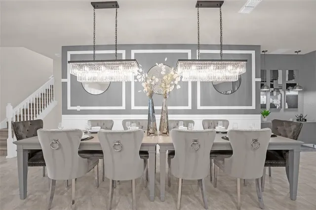 a view of a dining room with furniture a chandelier and kitchen view