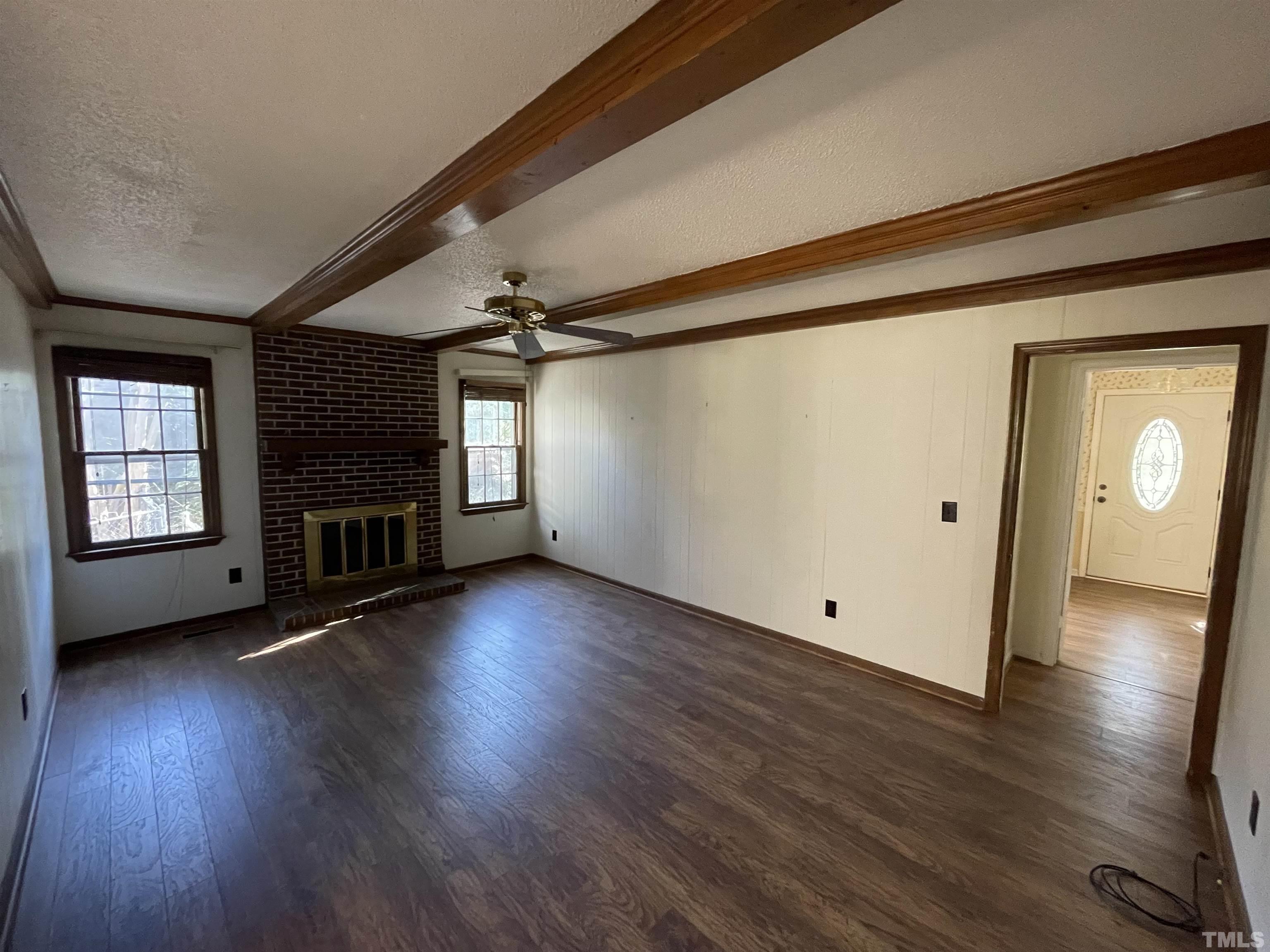 1429 Clermont Road Durham, NC 27713 - Photo 2 of 10 an empty room with wooden floor fireplace and windows