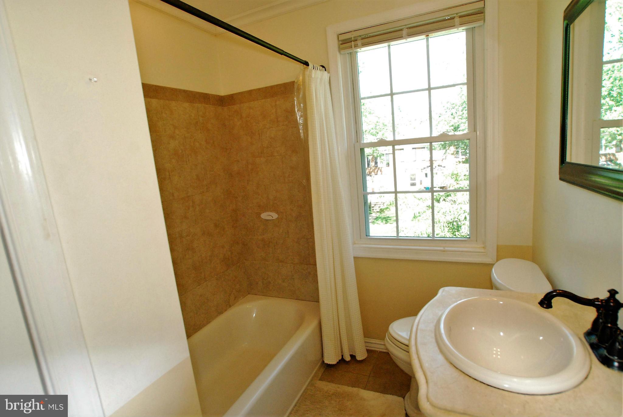 195 Stanmore Road Baltimore, MD 21212 - Photo 17 of 22 a bathroom with a sink a bathtub and a shower