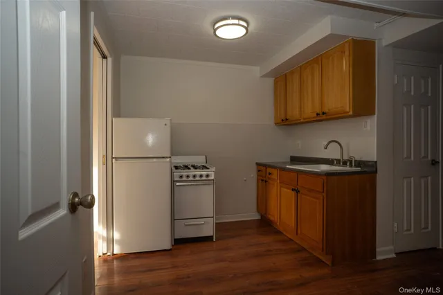 a kitchen with stainless steel appliances granite countertop a refrigerator a stove a sink and a microwave oven on the wooden floor