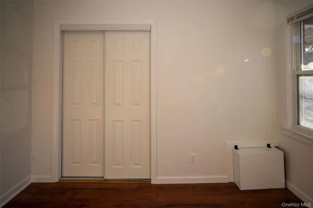 a view of room with hardwood floor and a window