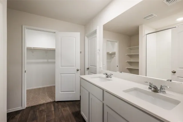 a bathroom with a double vanity sink and mirror