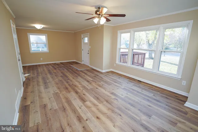 wooden floor in an empty room with a window