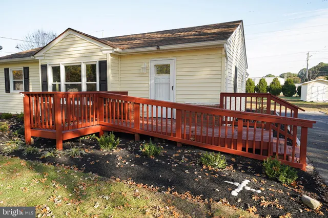 a view of a house with a yard and deck