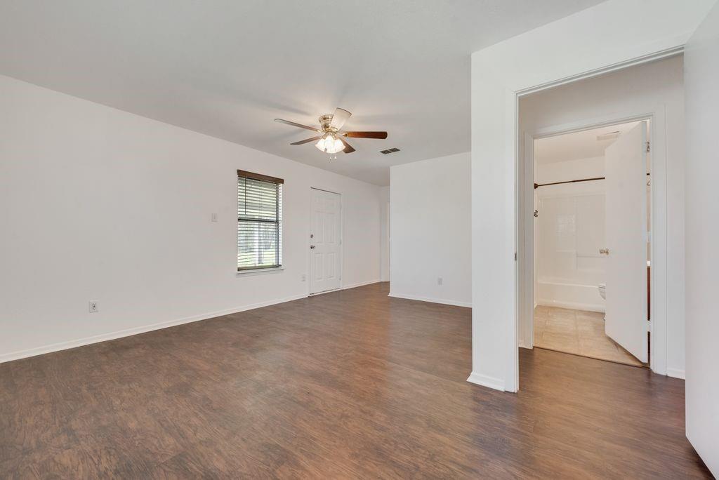 301 Lipscomb Street Cleburne, TX 76031 - Photo 12 of 21 an empty room with a windows and a ceiling fan