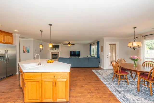 a dining room with furniture a chandelier and wooden floor