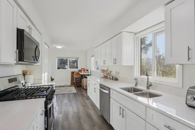 a kitchen with a sink stove top oven and cabinets