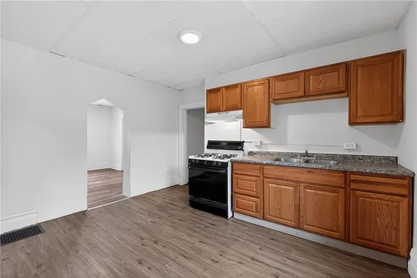 a kitchen with granite countertop wooden floors and stainless steel appliances