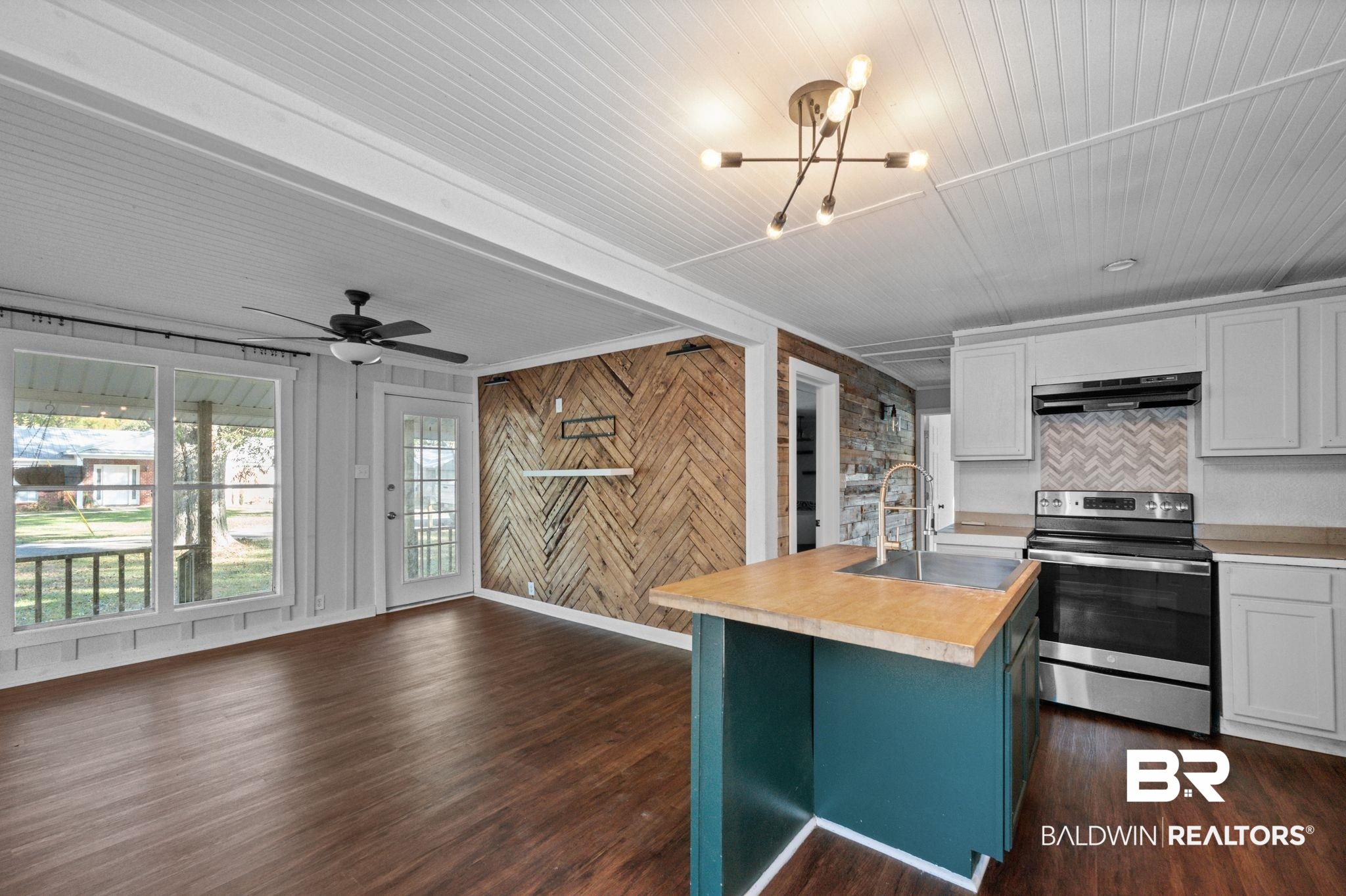 503 North Holly Street Foley, AL 36535 - Photo 8 of 23 Kitchen with stainless steel electric stove, white cabinetry, a kitchen island with sink, and dark wood-type flooring