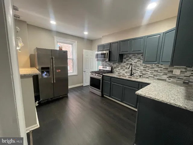 a kitchen with windows and refrigerator
