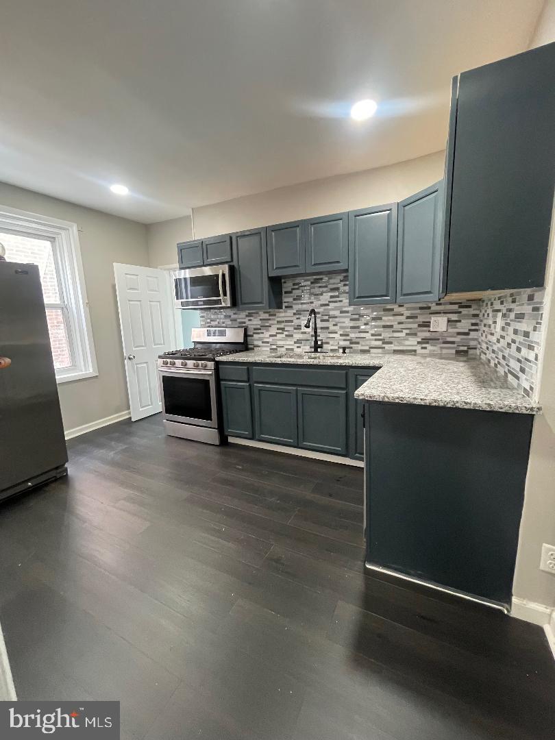1119 Chestnut Street Darby, PA 19023 - Photo 12 of 37 a kitchen with kitchen island granite countertop a sink and a stove top oven
