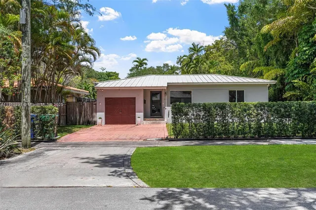 a front view of a house with a garden and yard
