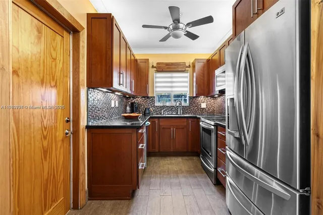 a kitchen with stainless steel appliances granite countertop a refrigerator and a sink