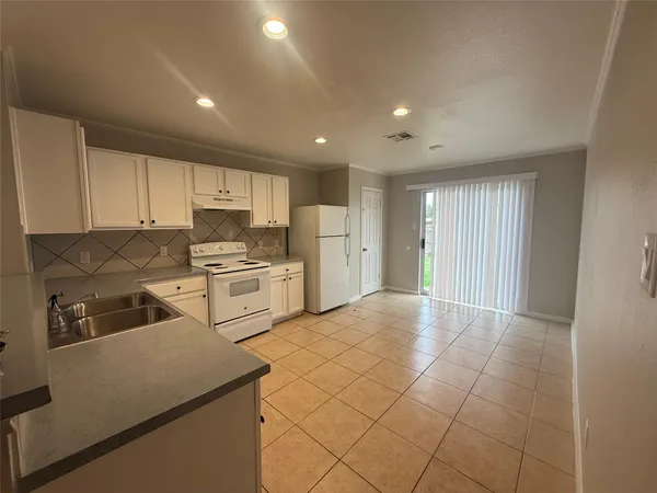 a kitchen with white cabinets and white appliances