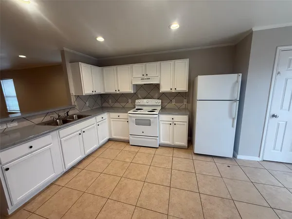 a kitchen with cabinets and white appliances