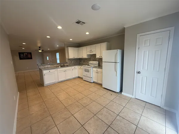 a kitchen with a refrigerator and a stove top oven